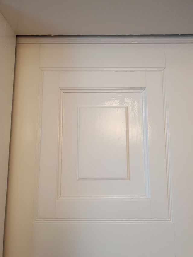 Białe drzwi z zaklejonymi szparami
