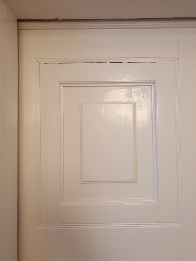Białe drzwi z wiocznymi szparami